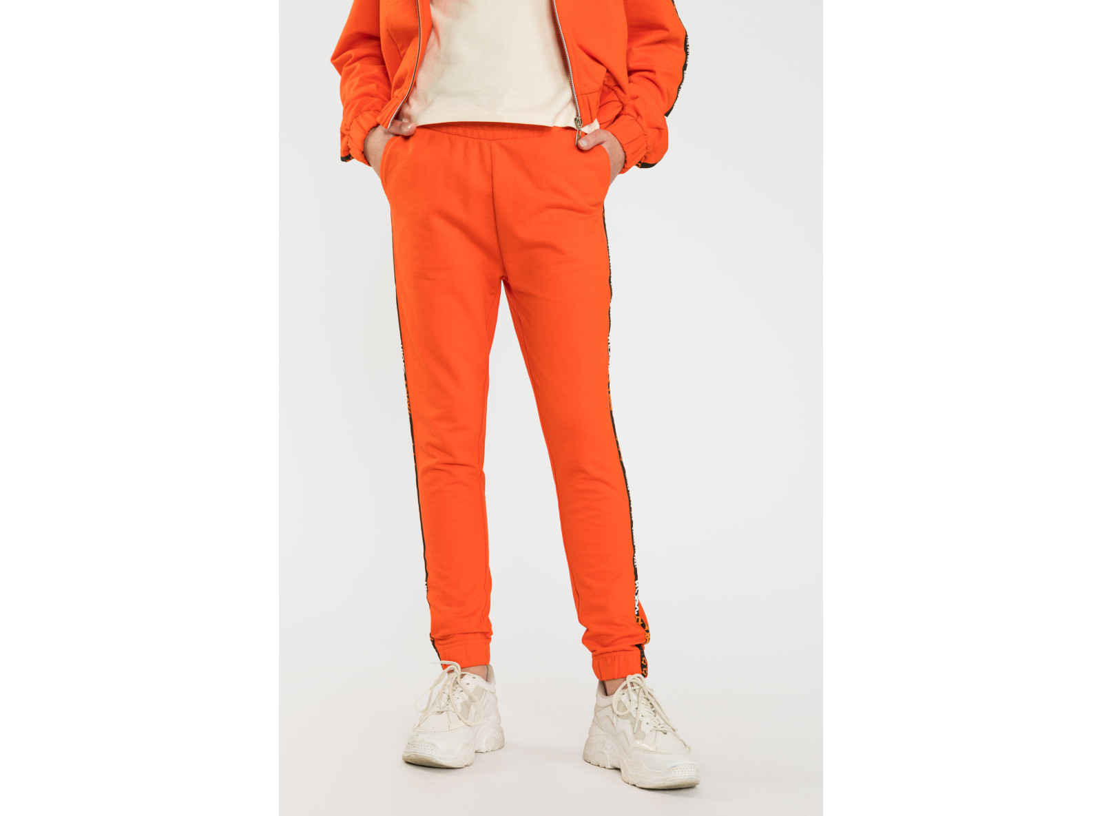 Pomarańczowe spodnie dresowe z ozdobnymi lampasami