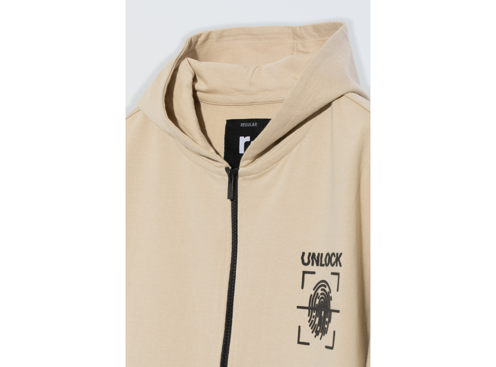 Beżowa bluza z kapturem z nadrukiem na wysokości piersi zapinana na zamek