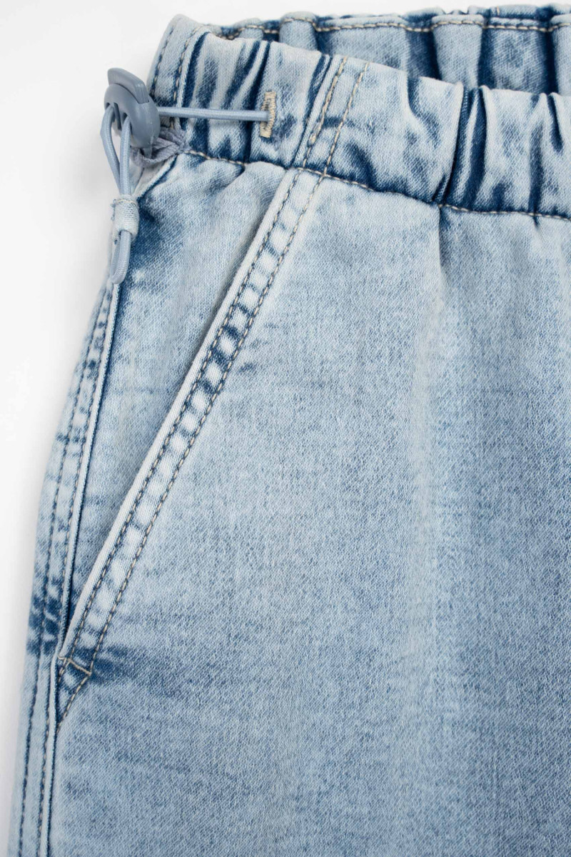 Niebieskie spodnie jeansowe typu PARACHUTE z zaszewkami na kolanach