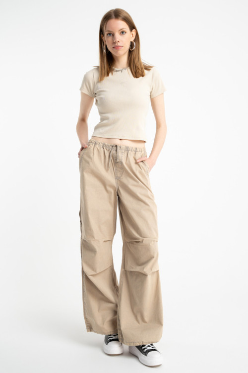 Beżowe spodnie typu PARACHUTE z zaszewkami na kolanach