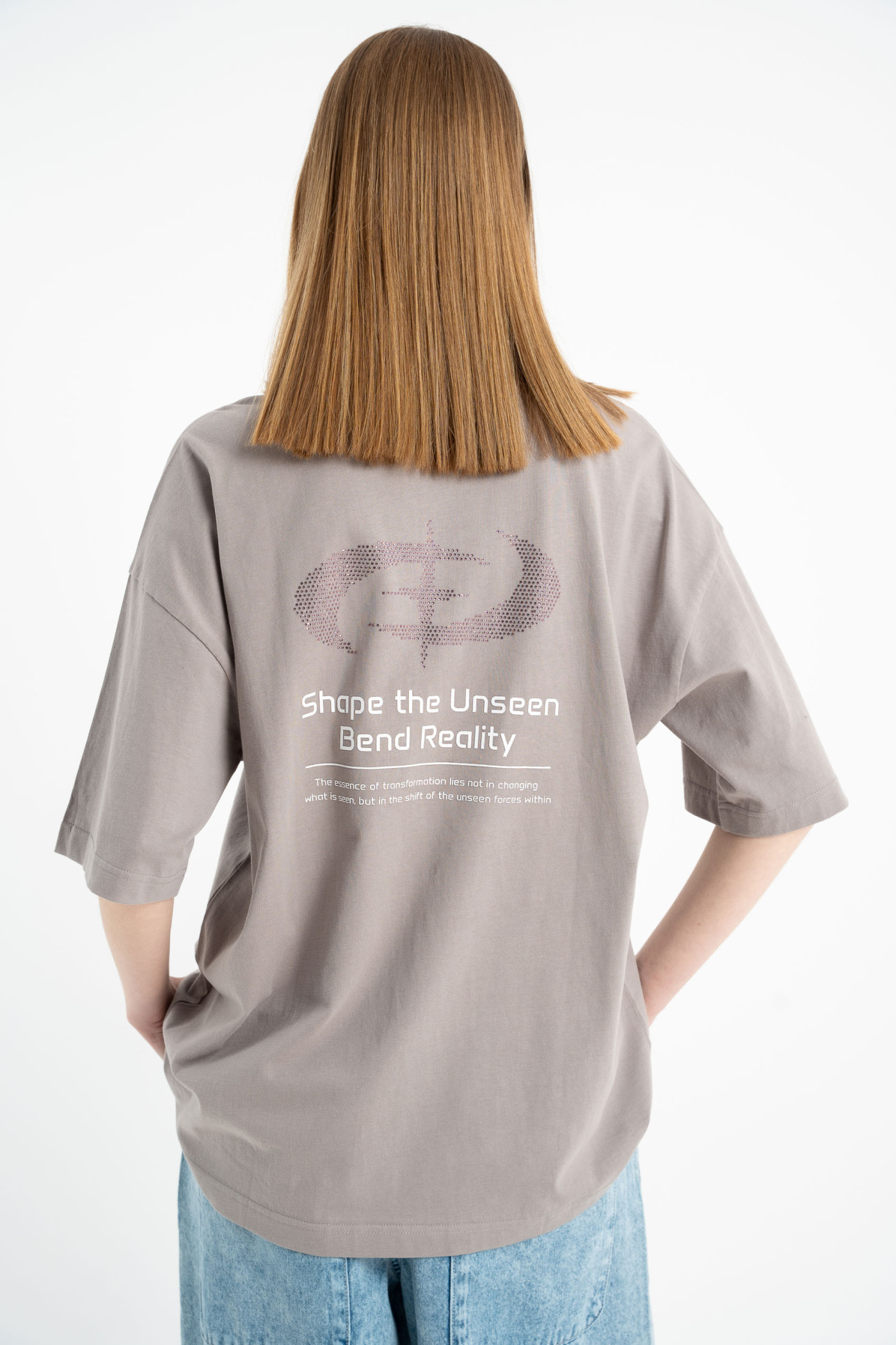 Beżowy t-shirt z autorskimi grafikami ozdobiony dżetami