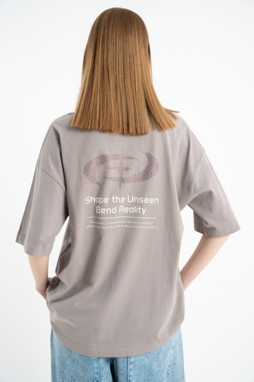 Beżowy t-shirt z autorskimi grafikami ozdobiony dżetami