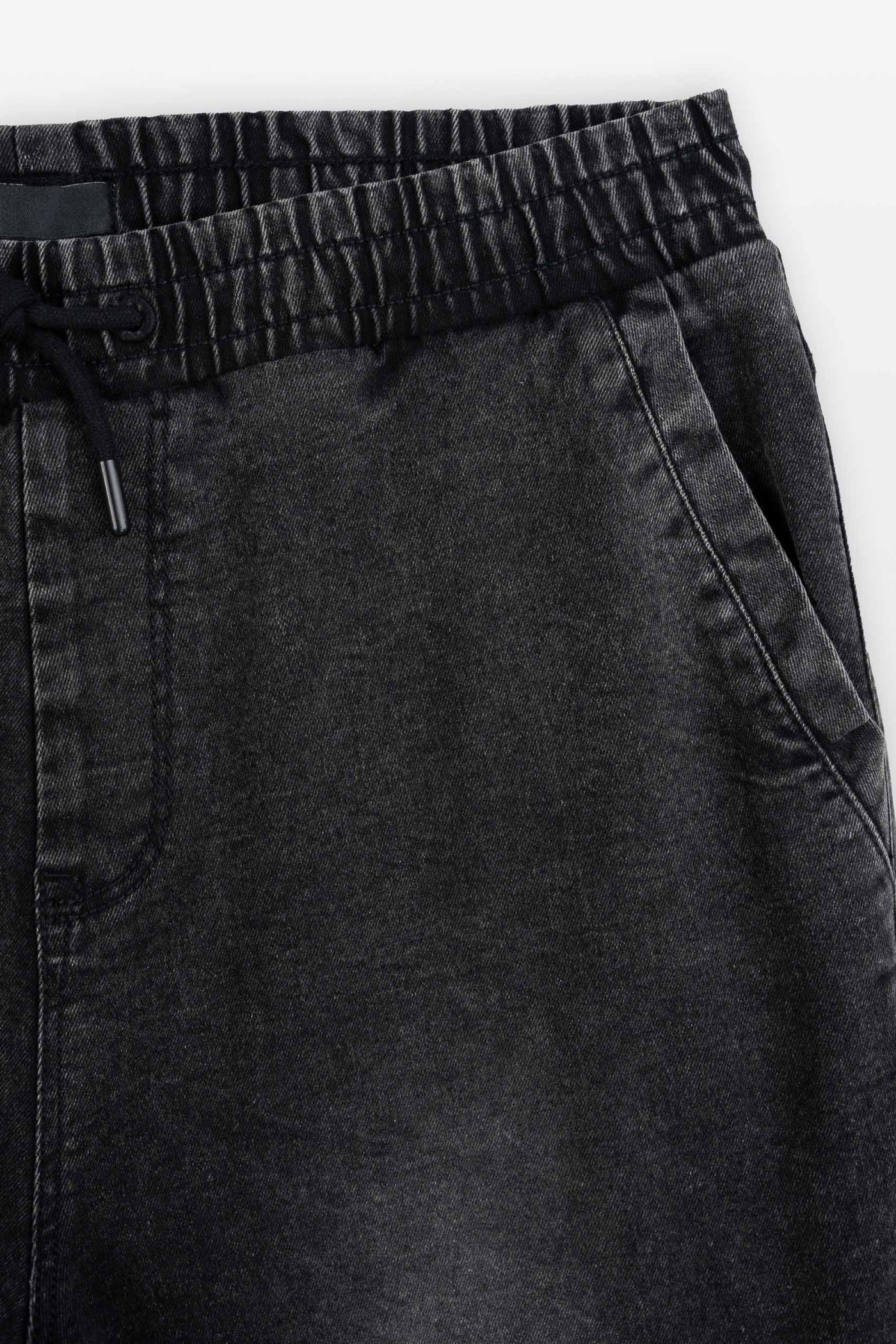 Czarne spodnie jeansowe typu joggery z modnymi przeszyciami