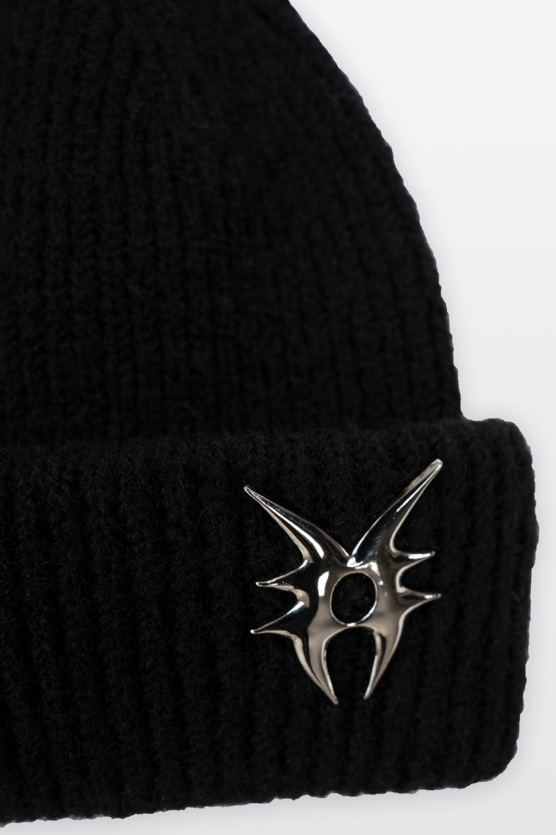 Czarna czapka z ozdobną metalową przypinką