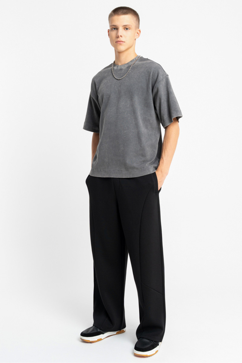 Czarne spodnie dresowe z szerokimi nogawkami z modnymi cięciami