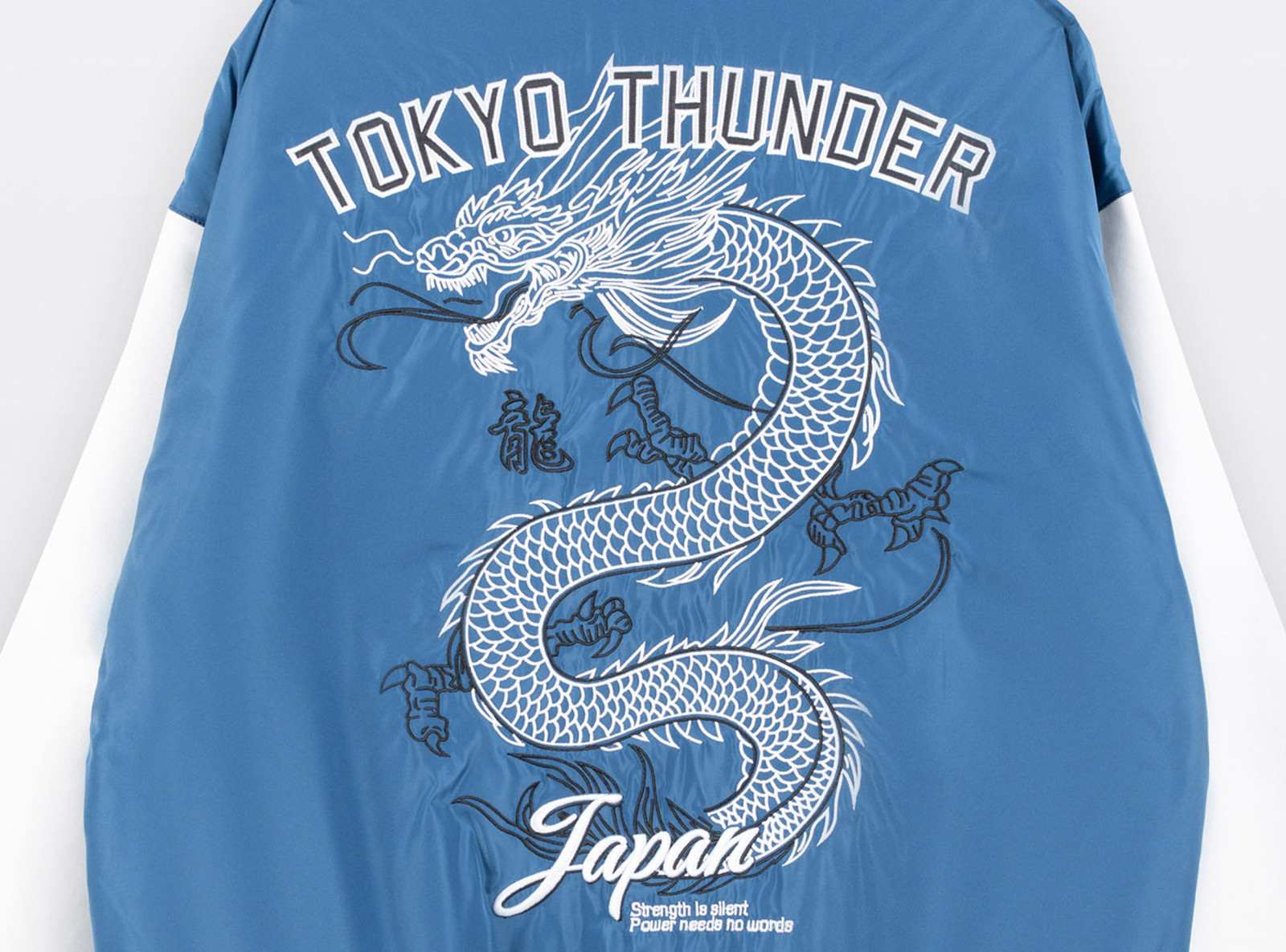 Biało-niebieska kurtka bomberka na stójce z modnym haftem