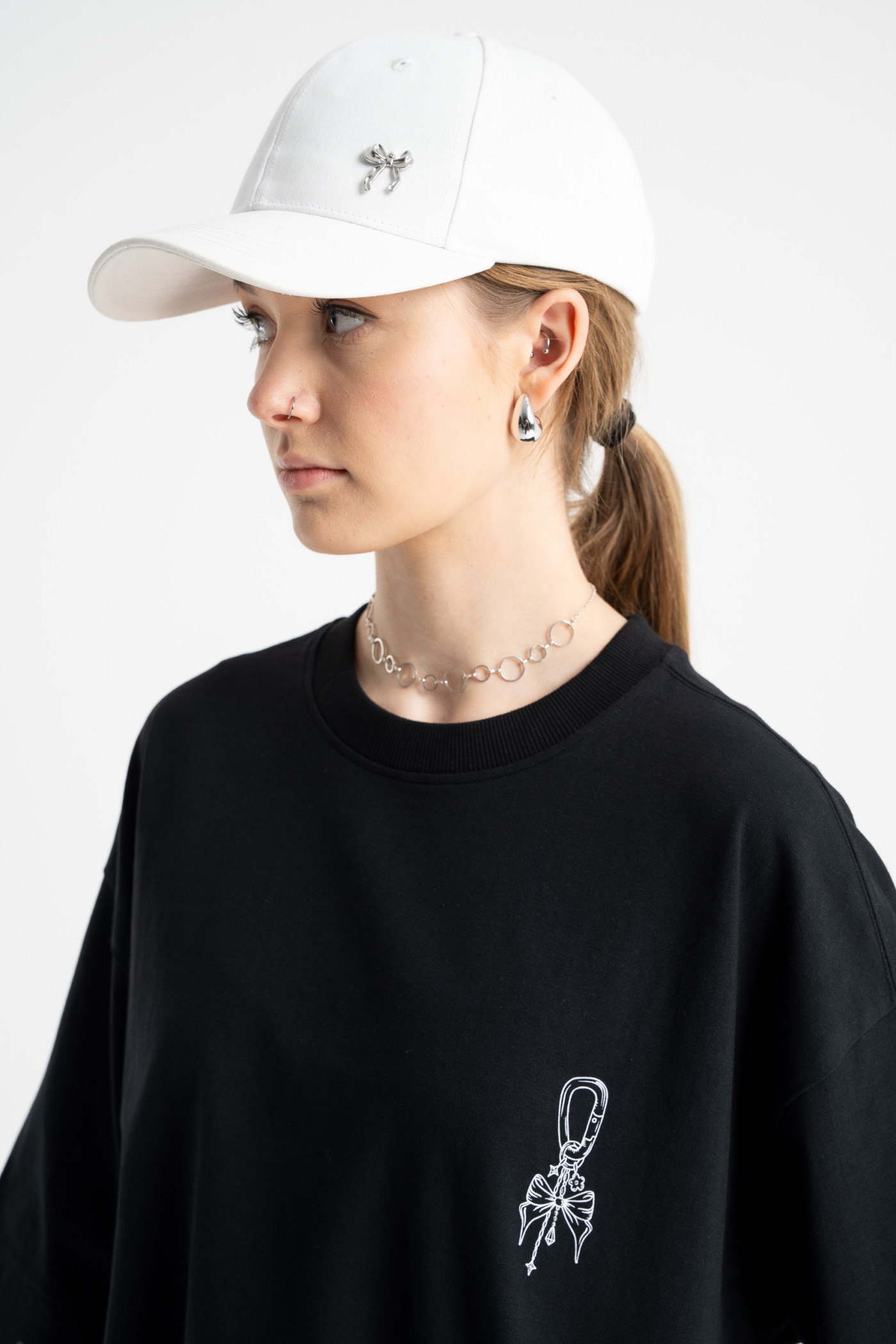 Biała czapeczka z minimalistyczną przywieszką z przodu