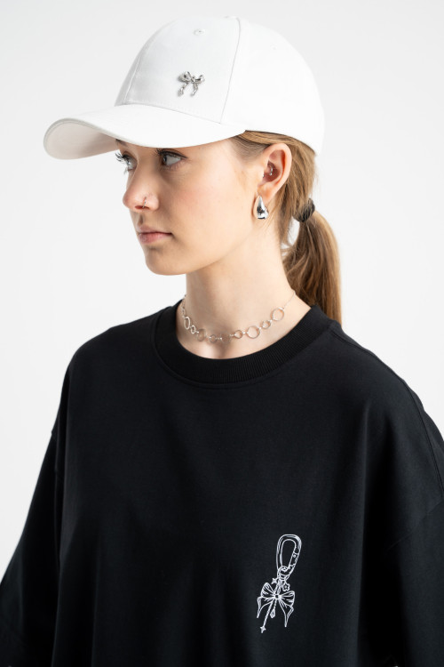 Biała czapeczka z minimalistyczną przywieszką z przodu