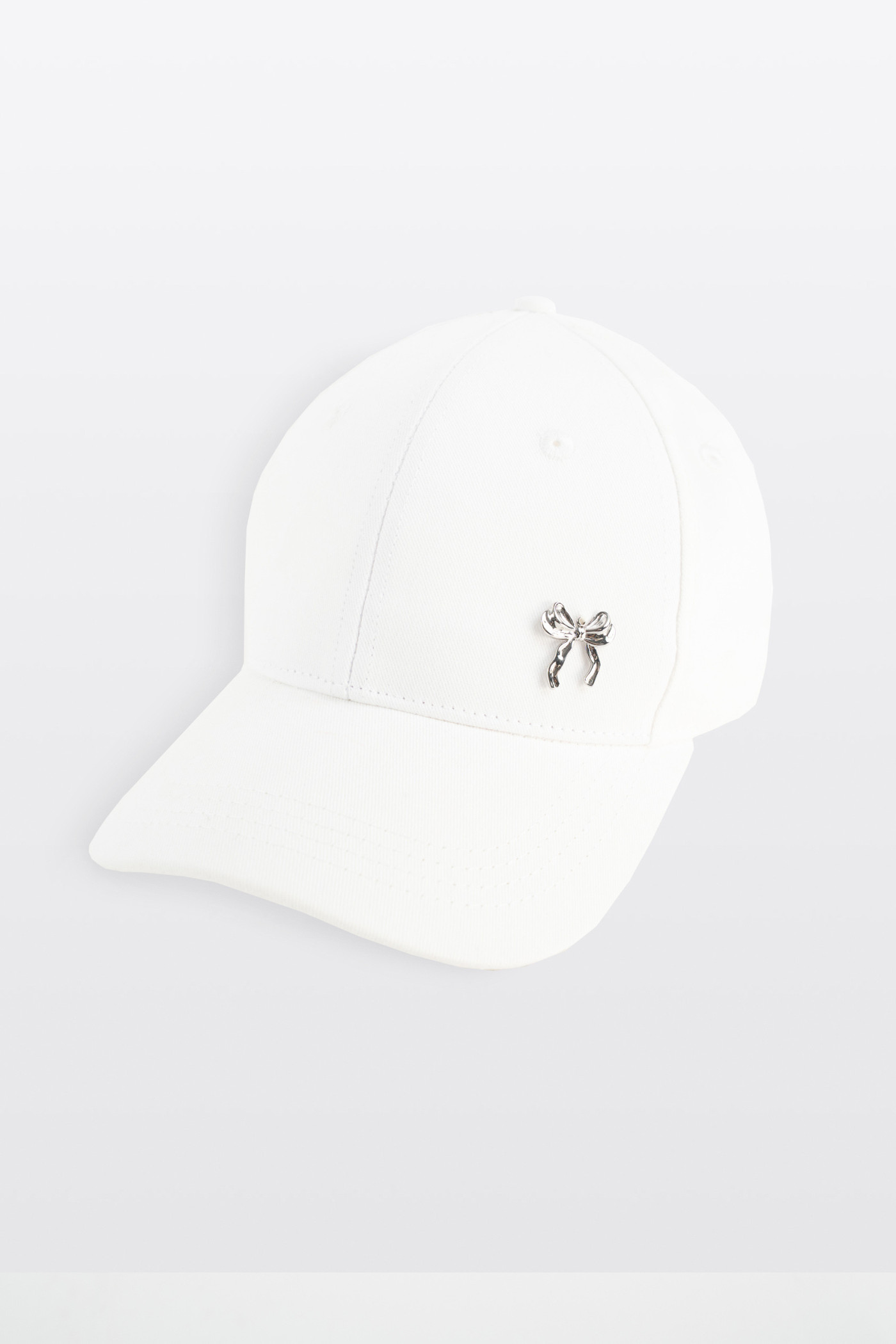 Biała czapeczka z minimalistyczną przywieszką z przodu