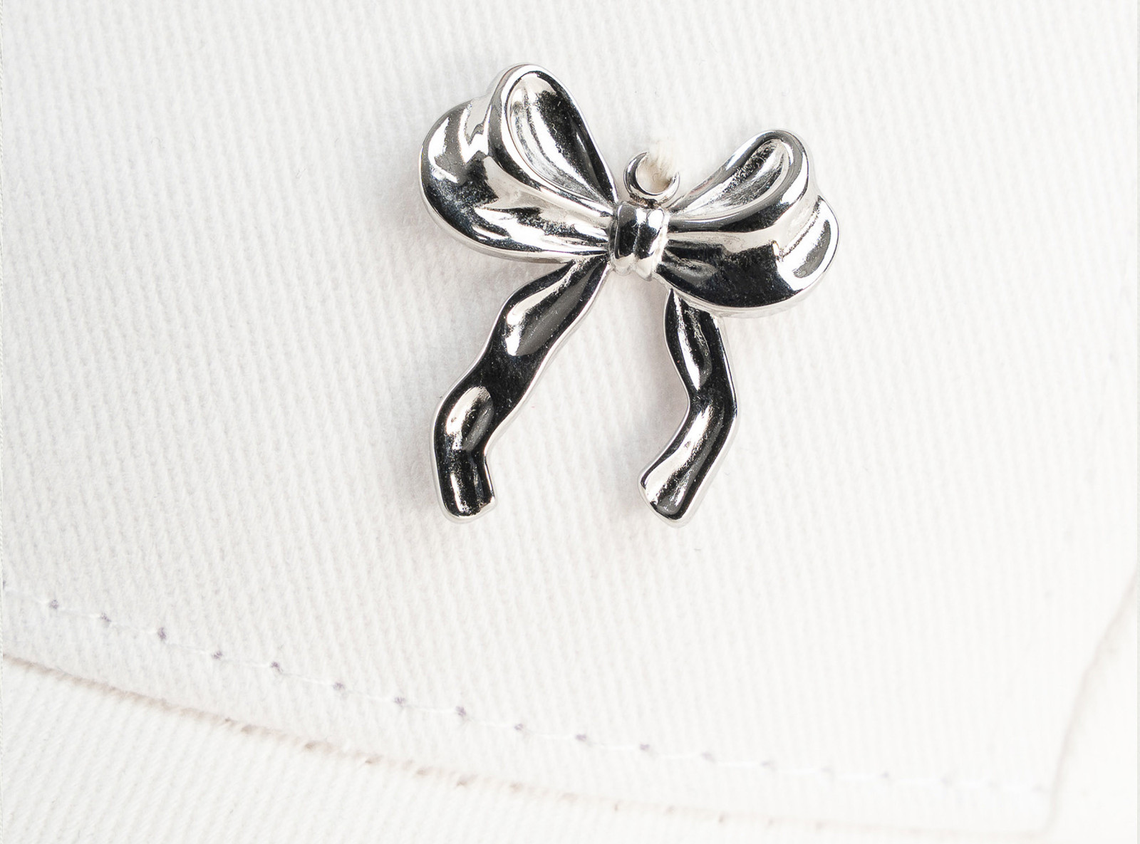 Biała czapeczka z minimalistyczną przywieszką z przodu